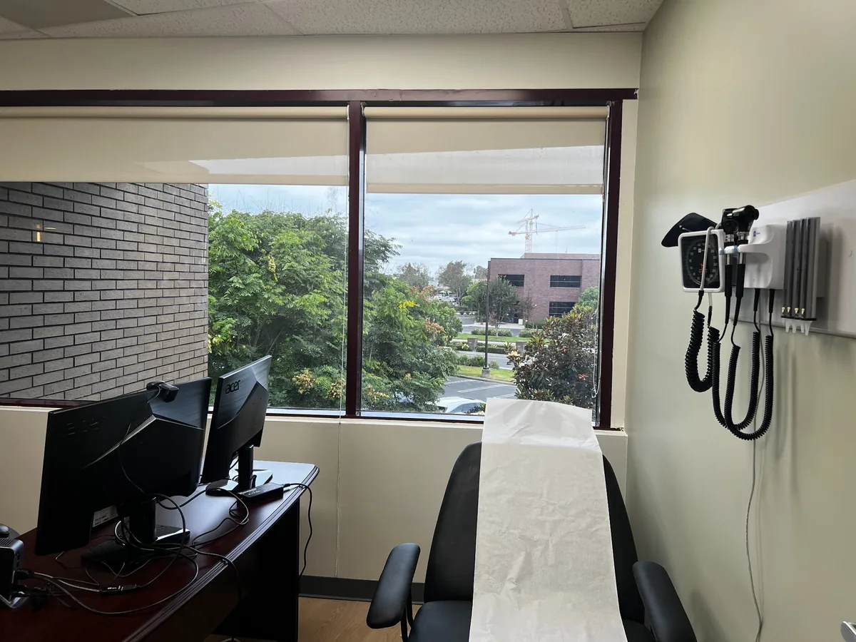 Exam chair with wall‑mounted otoscope/ophthalmoscope and blood pressure monitor